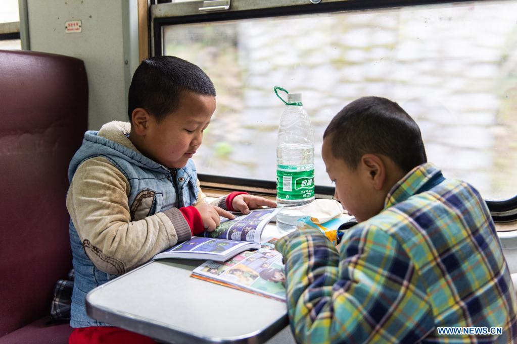 Children read books on the train 7266 in central China