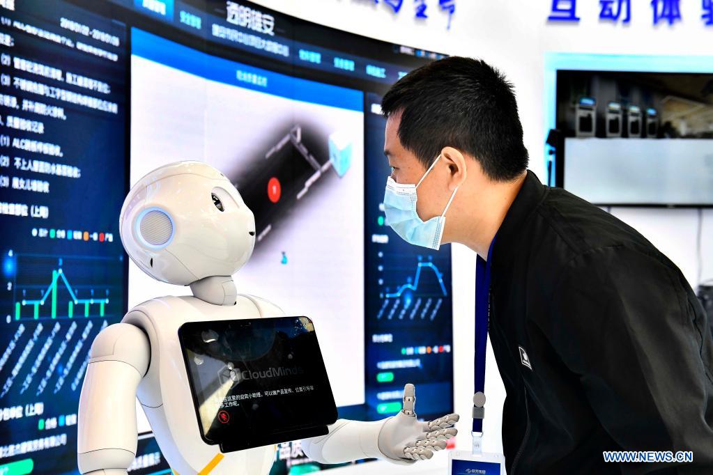 An attendee interacts with a robot during the 1st Summit of Jinan National Artificial Intelligence Innovation and Application (JNAIIA) Pilot Zone & the Exposition of Artificial Intelligence Innovation and Application on Yellow River Basin in Jinan, east China